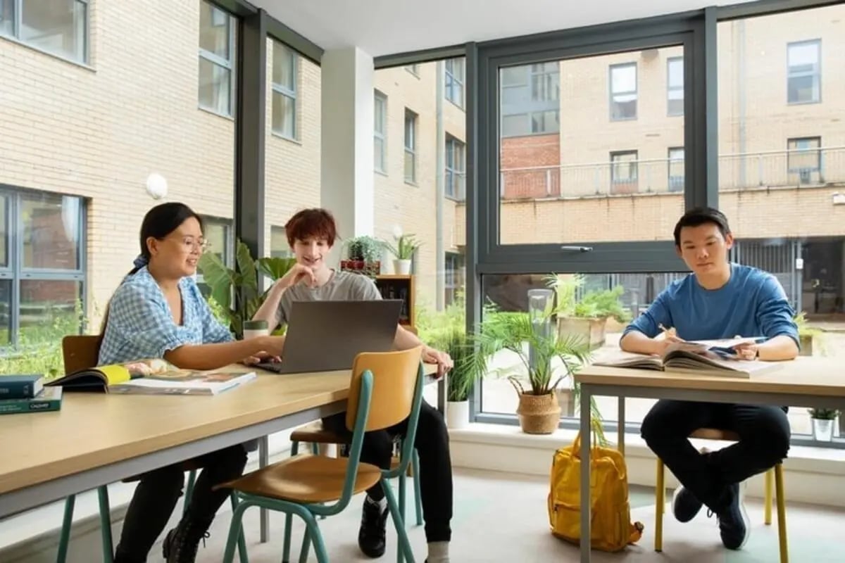 Students studying at tables with laptops and books study area at Kelvin Court in Glasgow Student Accommodation