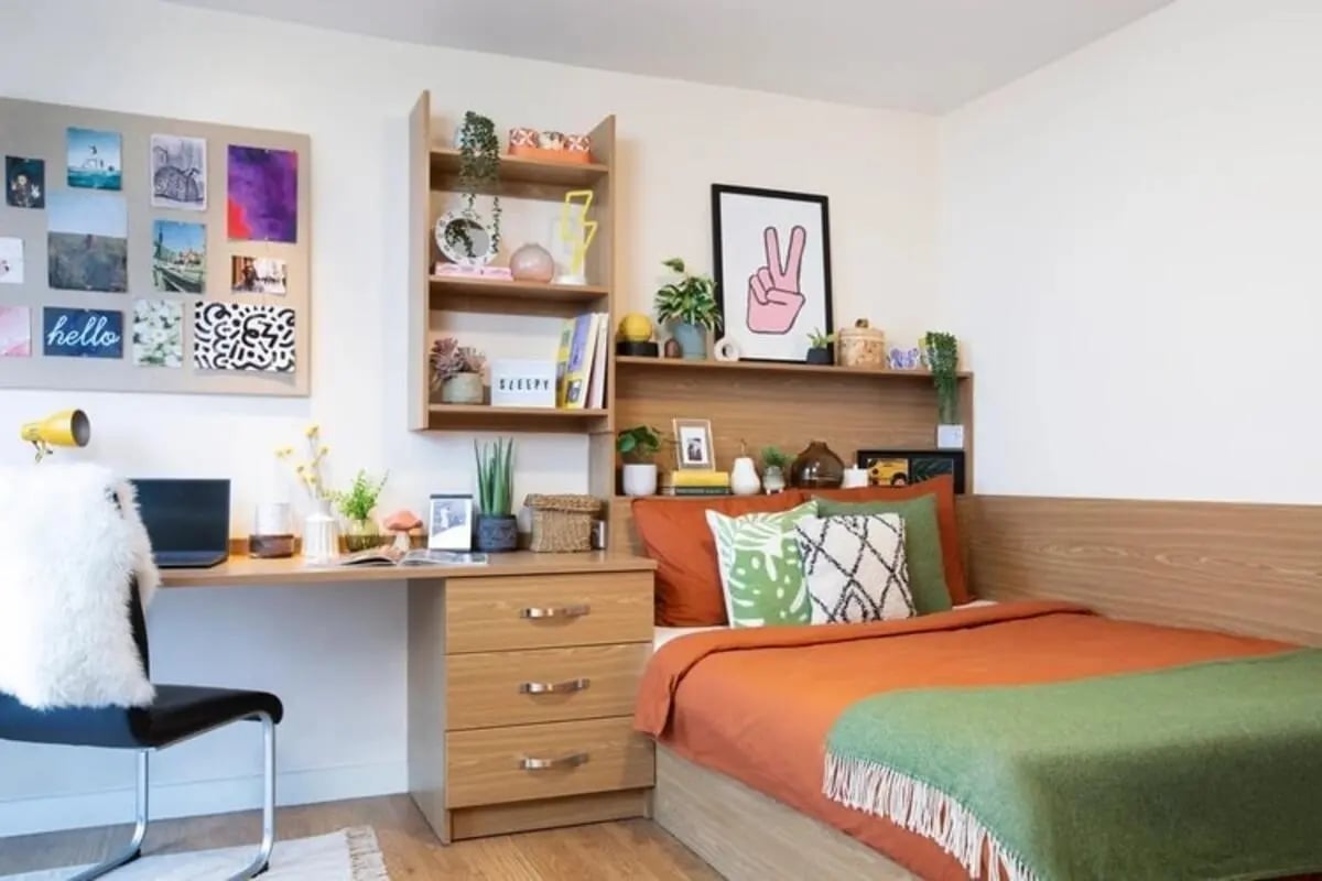 Desk bed shelving photos laptop and plants bedroom at Thurso Street in Glasgow Student Accommodation