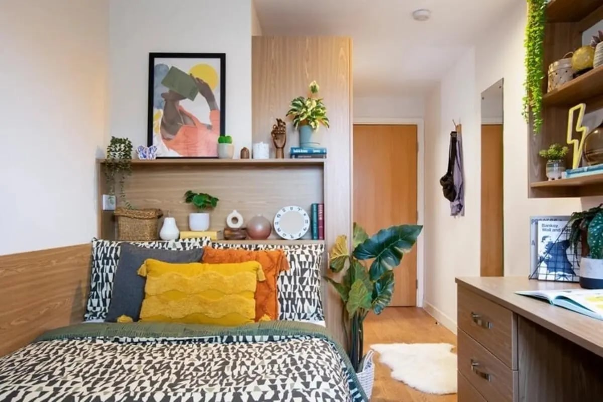 Bed with decorative pillows and wall art bedroom at Thurso Street in Glasgow Student Accommodation