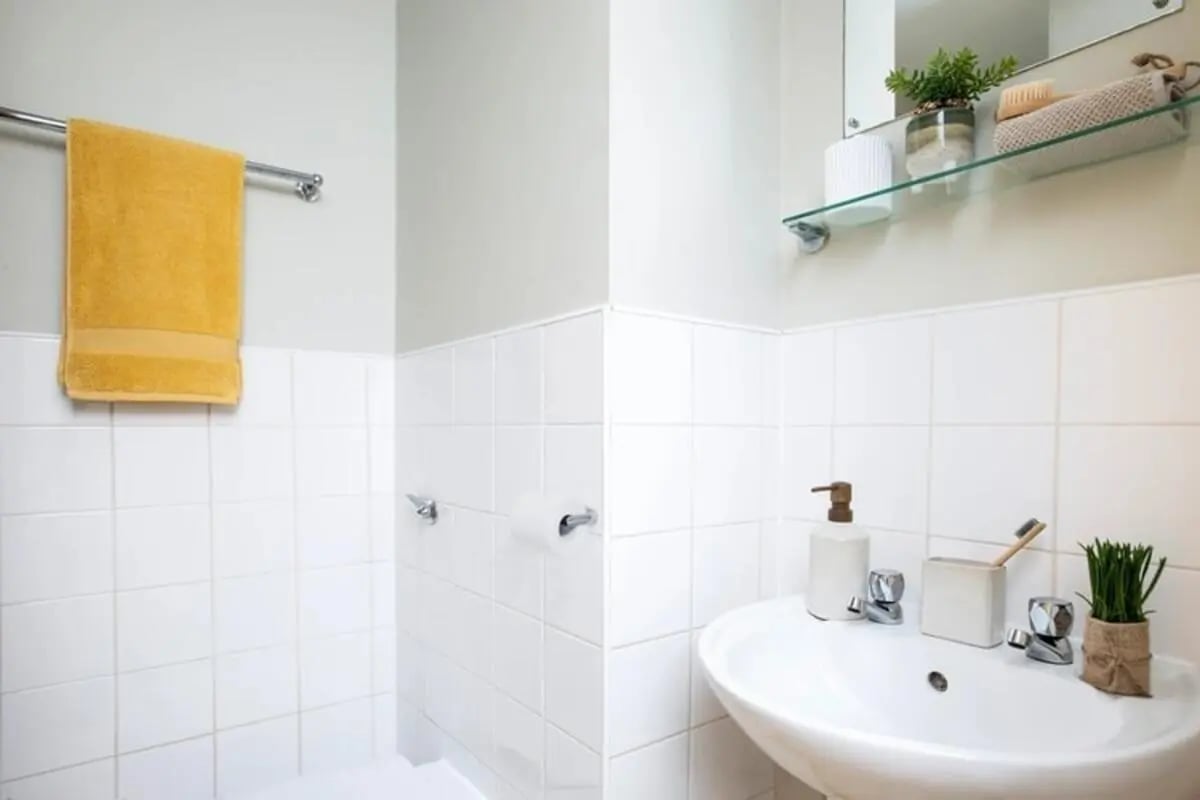 Yellow towel soap dispenser toothbrush holder bathroom at Kyle Park House in Glasgow Student Accommodation