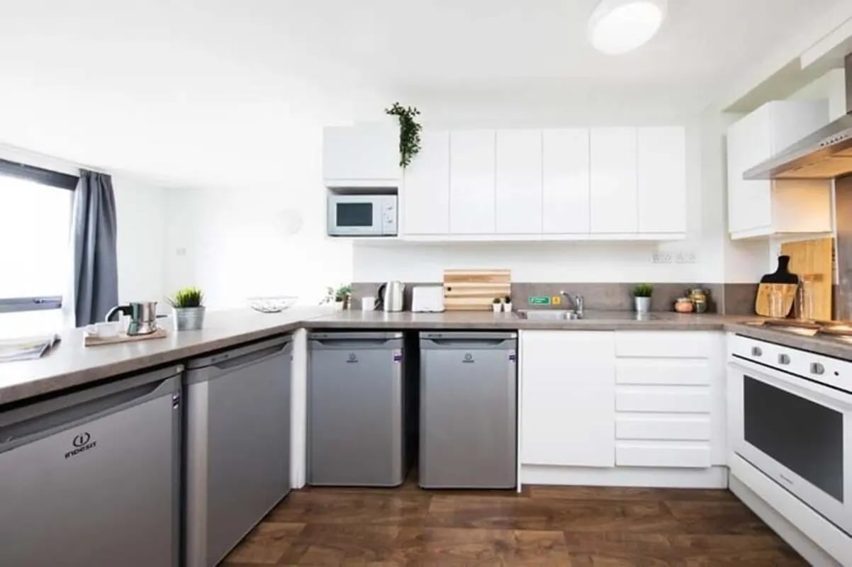 Mini fridges microwave cabinets sink oven kitchen at Kyle Park House in Glasgow Student Accommodation