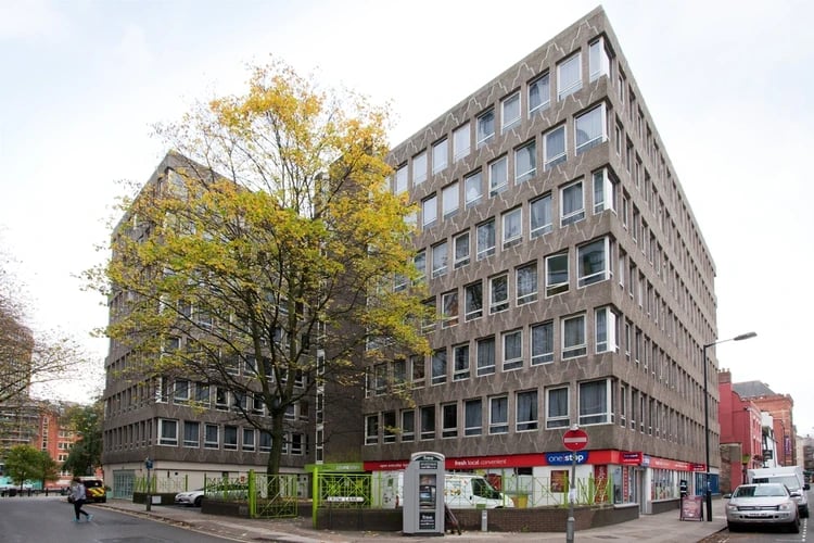 Concrete building with many windows and a shop exterior at Favell House in Bristol Student Accommodation