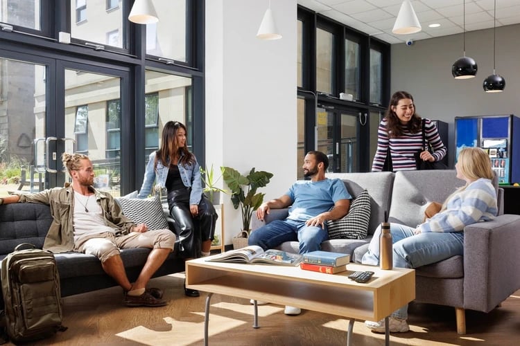Students relaxing on sofas in communal living space at Chalmers Street in Edinburgh Student Accommodation