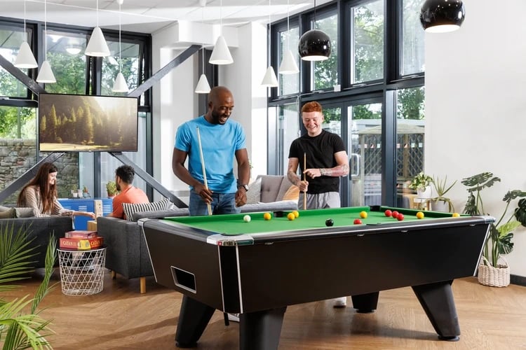 Pool table and sofas with students playing living room at Chalmers Street in Edinburgh Student Accommodation