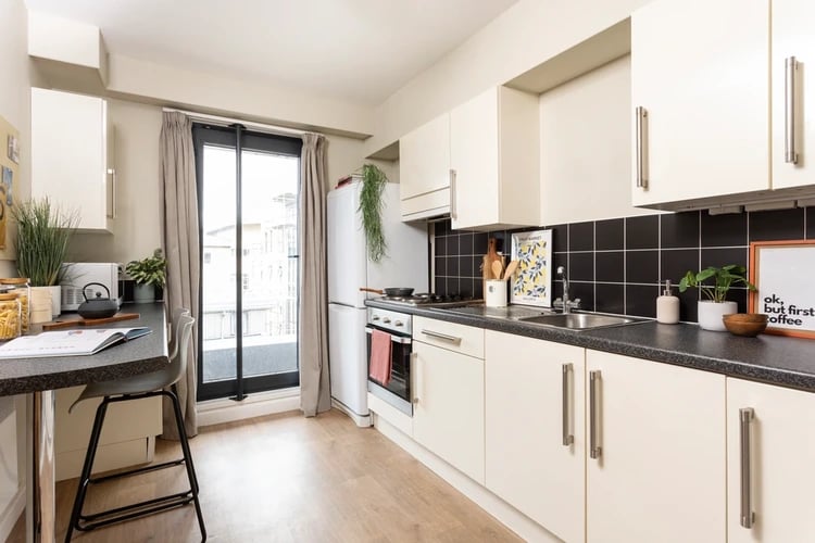 Cream cabinets fridge stove sink and counter kitchen at Chalmers Street in Edinburgh Student Accommodation