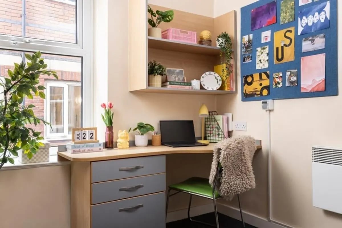 Desk with laptop plants and calendar study area at Lennon Studios in Liverpool Student Accommodation