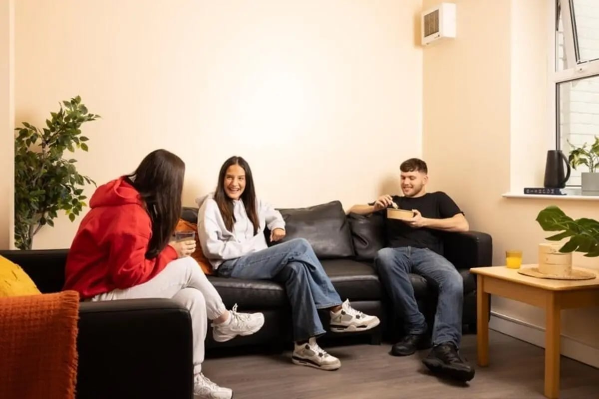 Three friends relaxing on sofa in lounge living room at Lennon Studios in Liverpool Student Accommodation