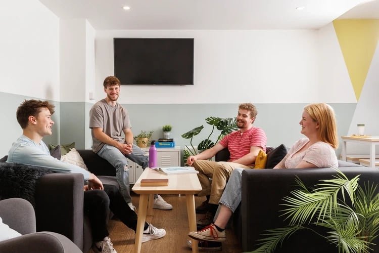 Four students on sofas near television living room at The Old Printworks in Edinburgh Student Accommodation