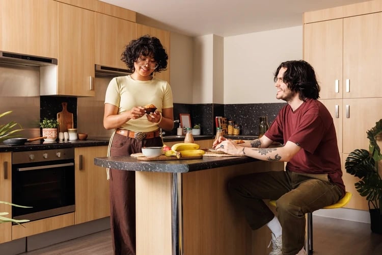 Two people preparing food in kitchen kitchen at The Old Printworks in Edinburgh Student Accommodation