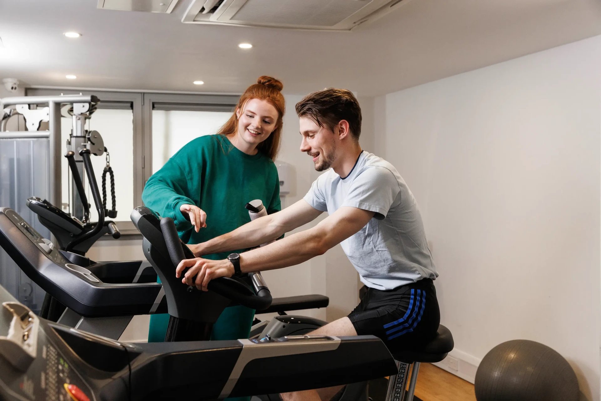 Couple exercising on stationary bikes gym equipment. at The Old Printworks in Edinburgh Student Accommodation