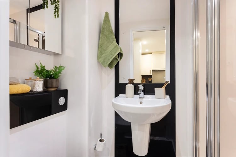 Sink soap dispenser toiletries green towel bathroom at Salisbury court in Edinburgh Student Accommodation
