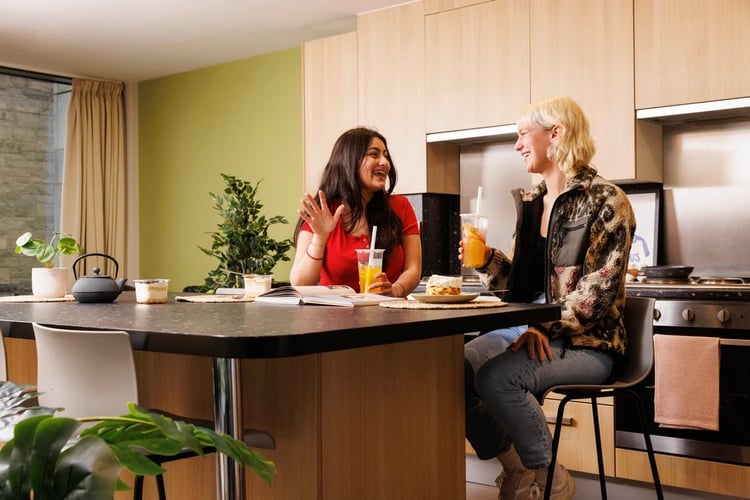 Two women drinks and food kitchen Image at Salisbury court in Edinburgh Student Accommodation