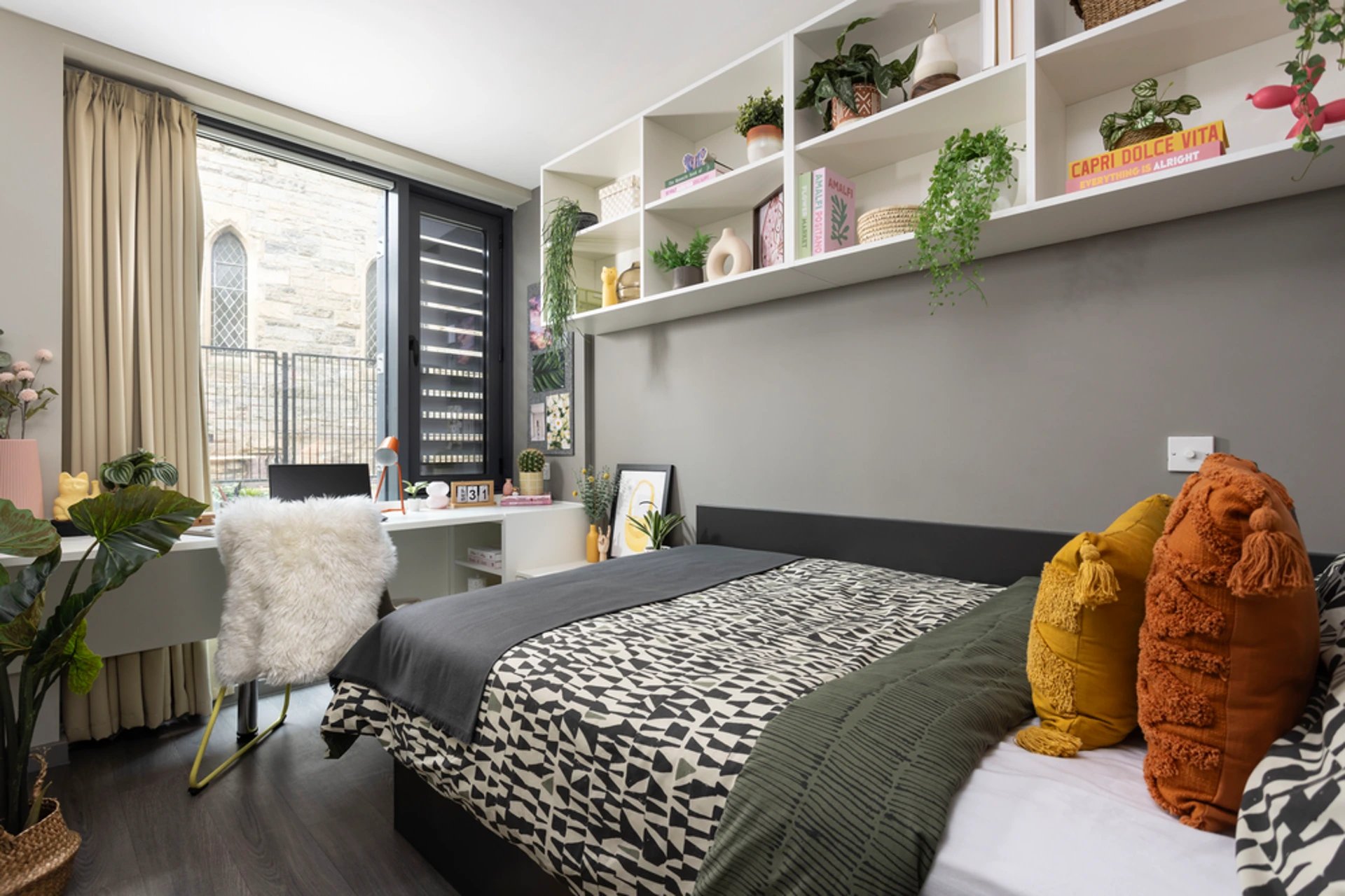 Bed with patterned duvet fluffy chair desk bedroom at Salisbury court in Edinburgh Student Accommodation