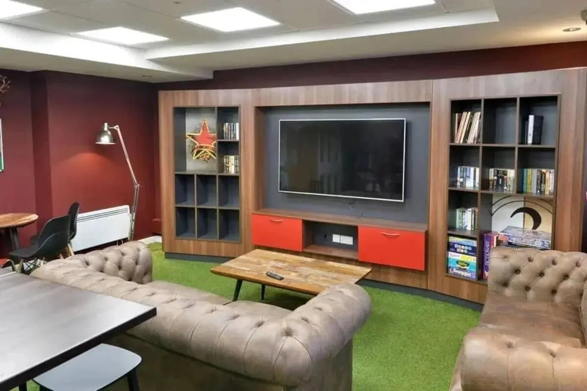 Sofas television bookshelf and coffee table lounge at Wardley House in Bradford Student Accommodation