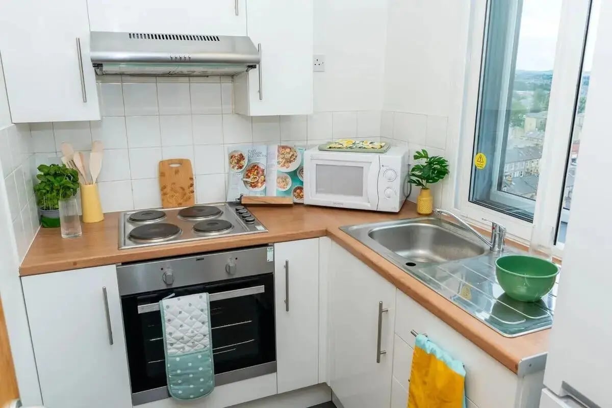 Compact kitchen with oven microwave and sink kitchen at Wardley House in Bradford Student Accommodation
