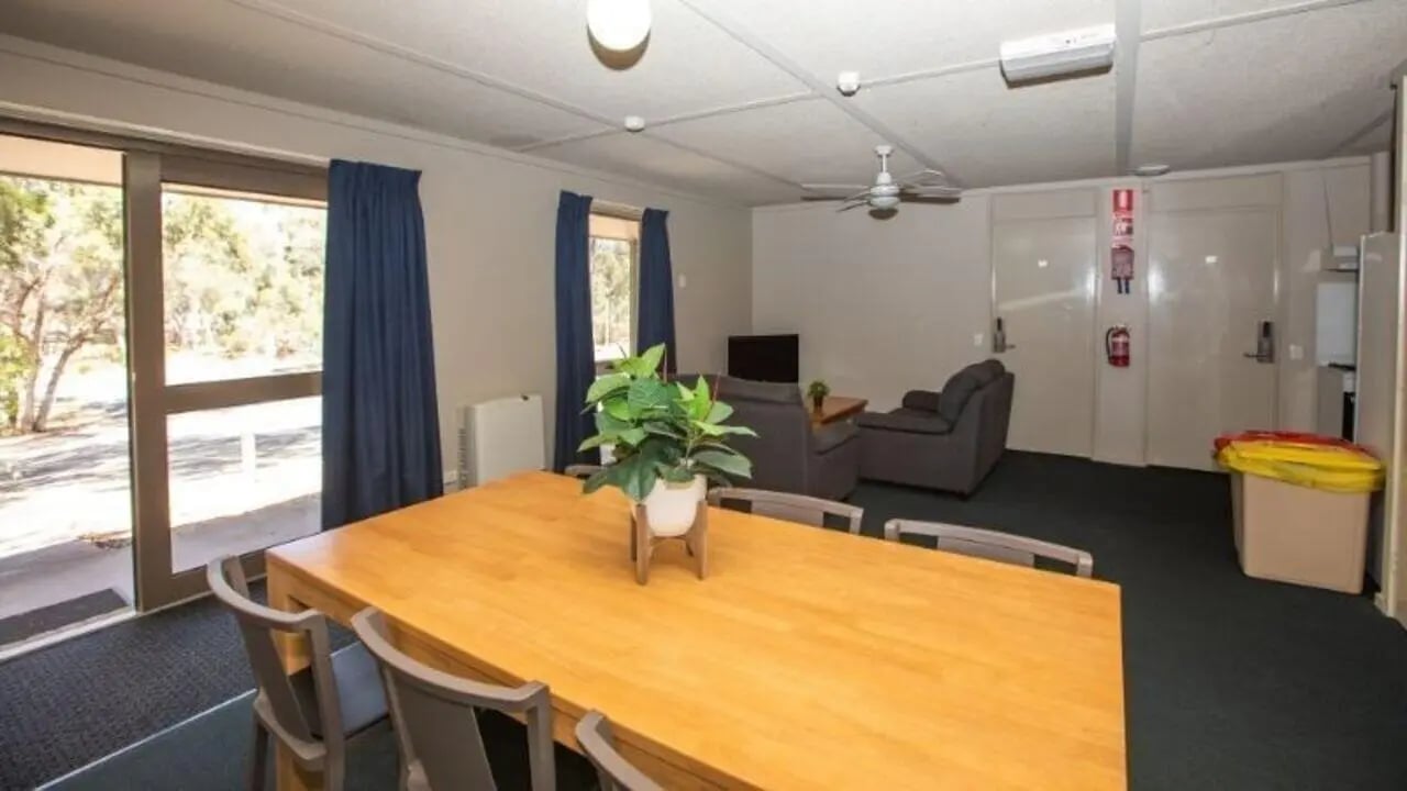 Wooden table chairs plant sofas living room at La Trobe University - Villas in Melbourne Student Accommodation
