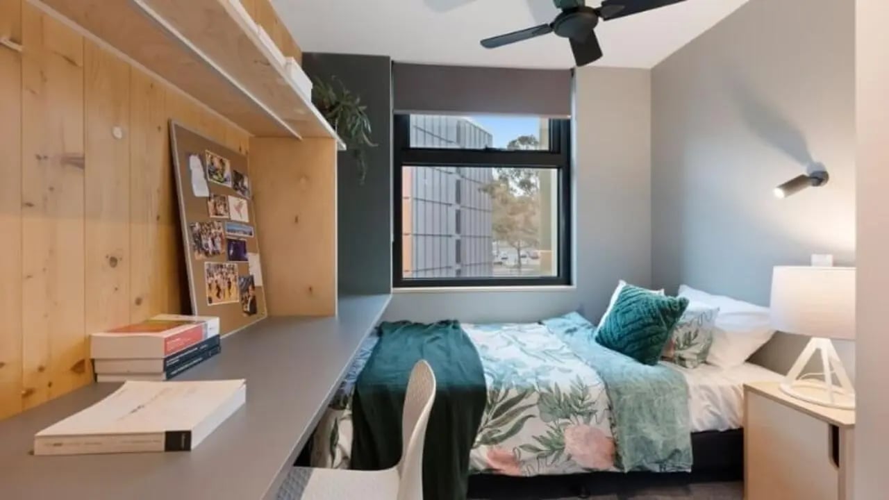 Bed desk corkboard ceiling fan bedroom at La Trobe University - North and South Apartments in Melbourne Student Accommodation