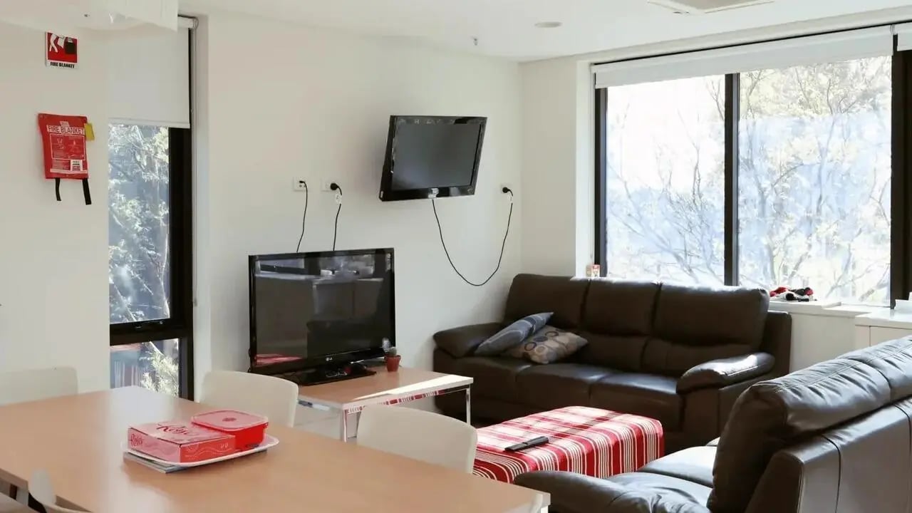 Sofas televisions dining table living room at La Trobe University - McFarlane's Hill Residences in Wodonga Student Accommodation