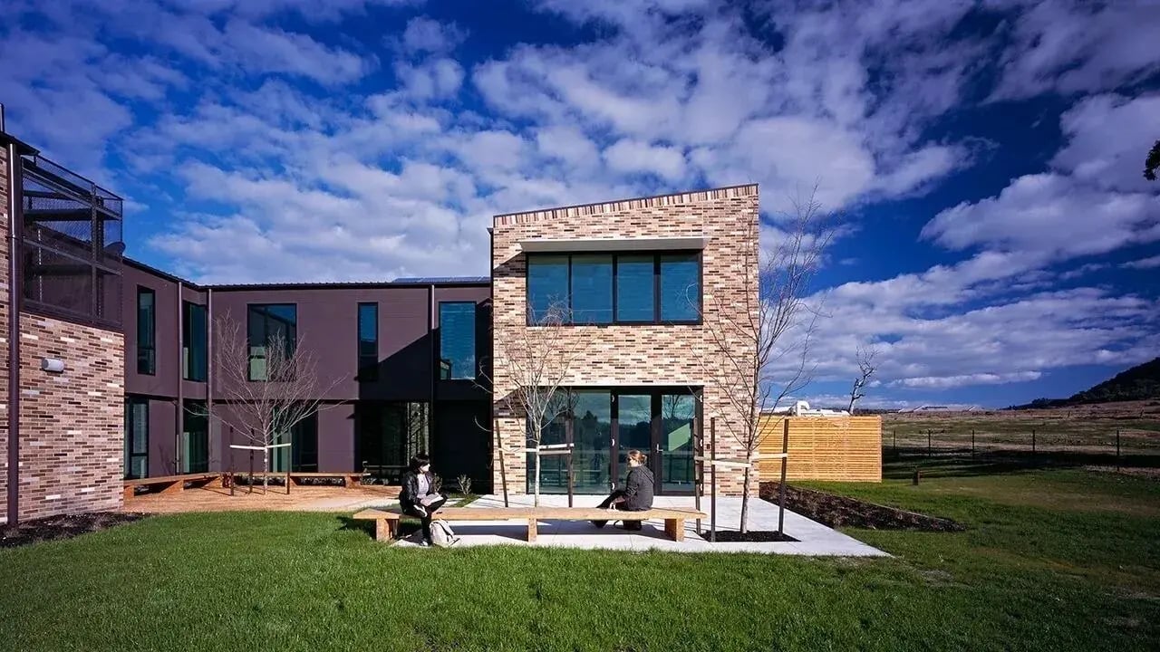 Two people on benches outdoors exterior at La Trobe University - McFarlane's Hill Residences in Wodonga Student Accommodation