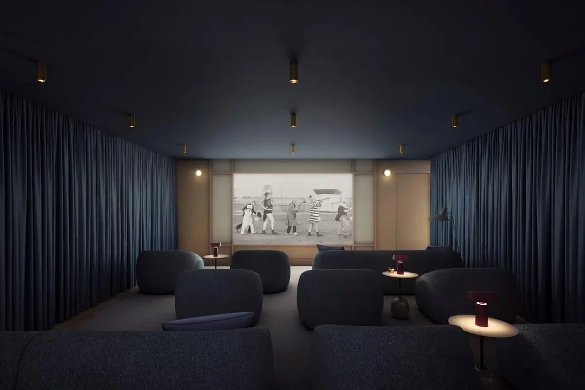 Dark seating and tables projected movie screen cinema room at Chapter London Bridge in London Student Accommodation