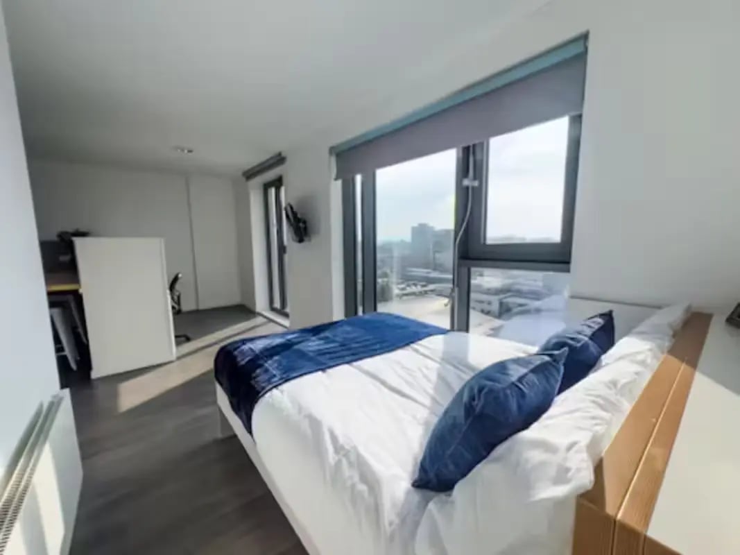 Bed with blue accents desk and radiator bedroom at Dobbie's Point in Glasgow Student Accommodation