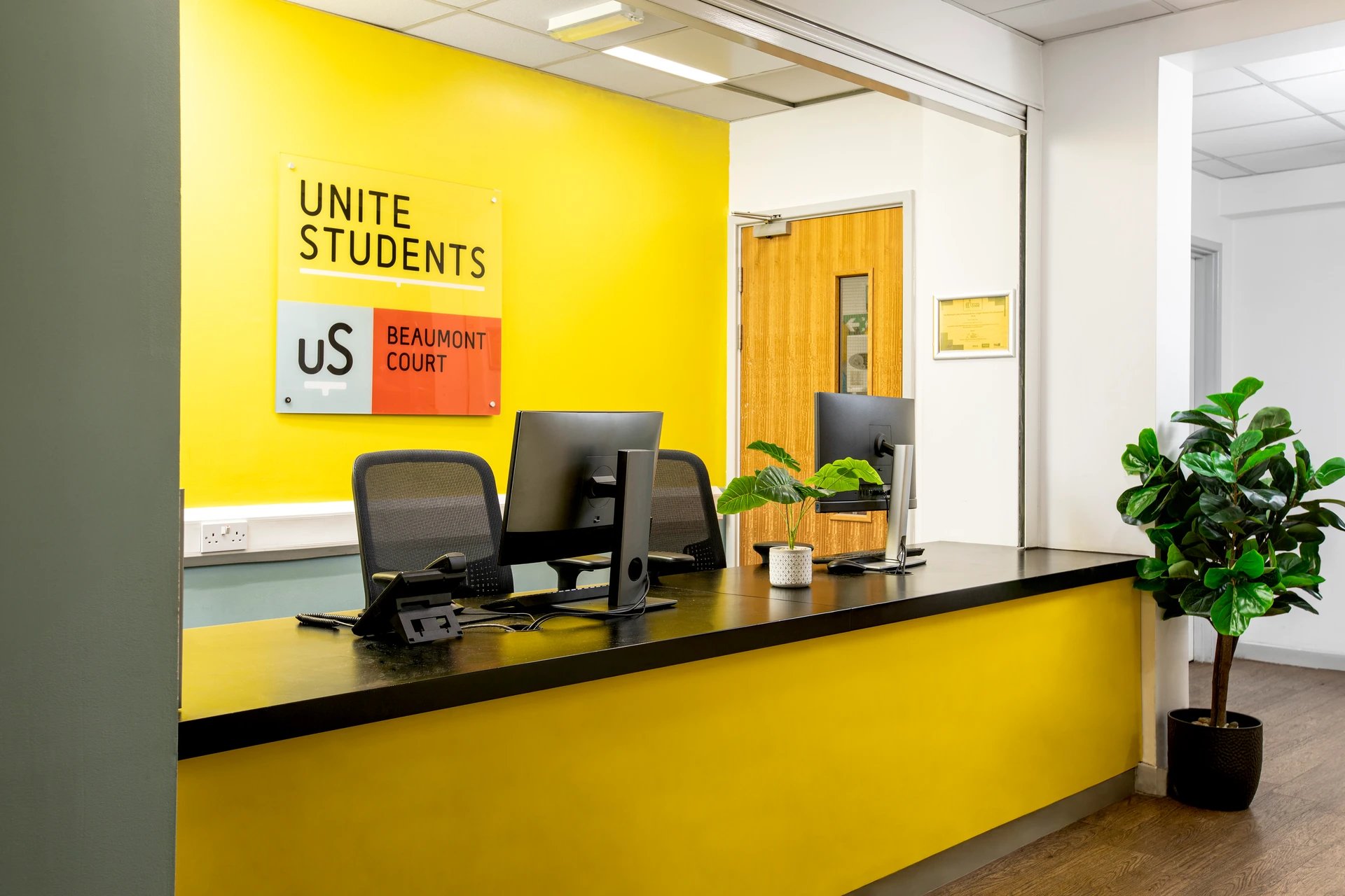 Reception desk with computers and chairs reception area at Beaumont Court in London Student Accommodation