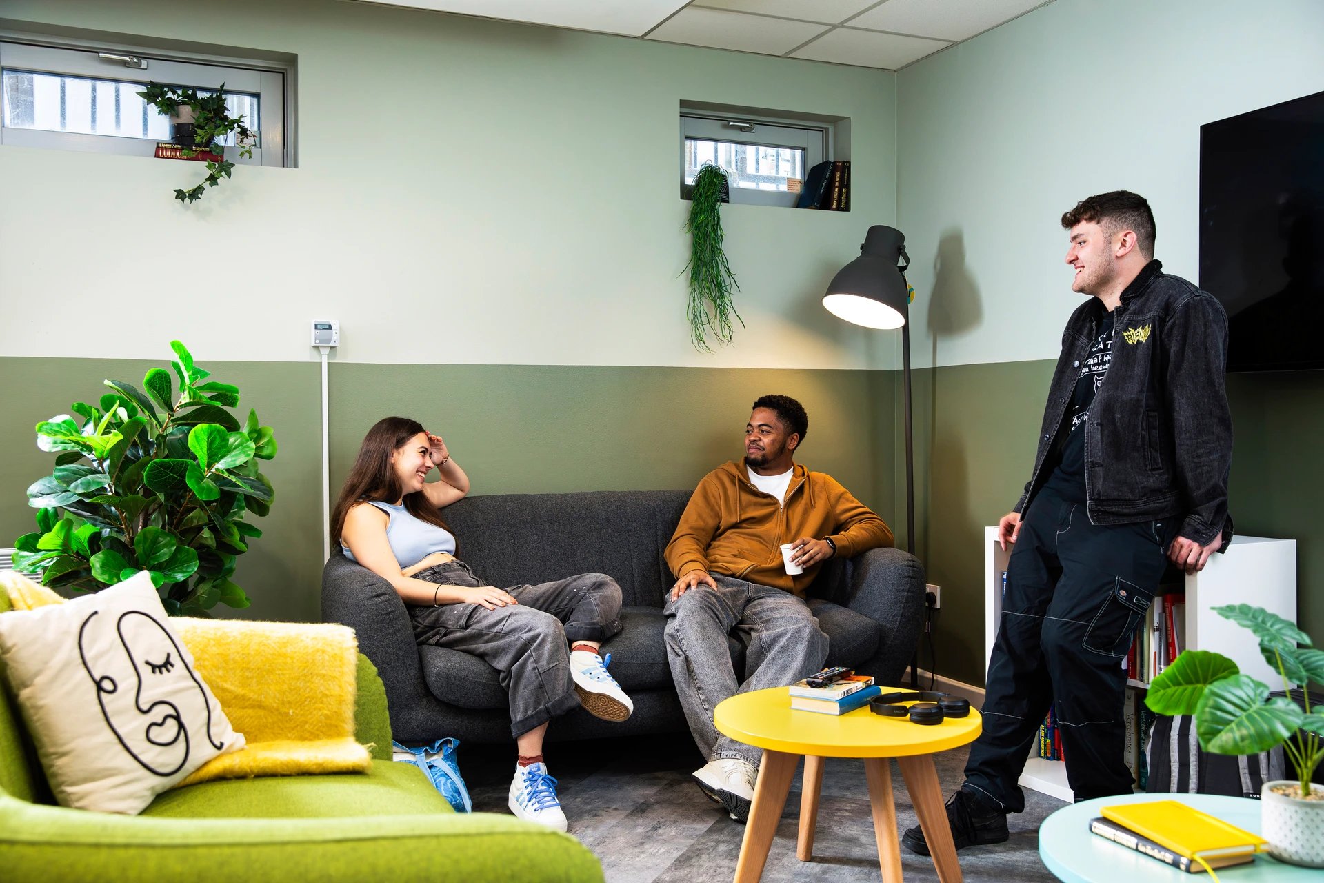 Sofa lamp table plants three students living room at Beaumont Court in London Student Accommodation