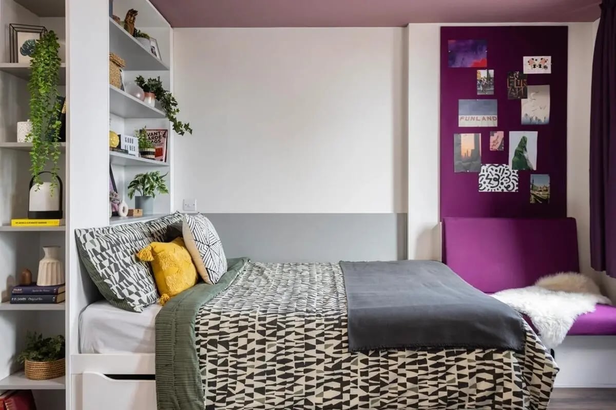 Bed with patterned bedding shelves and purple seating Bedroom at Wellington St Plaza in Newcastle Upon Tyne Student Accommodation