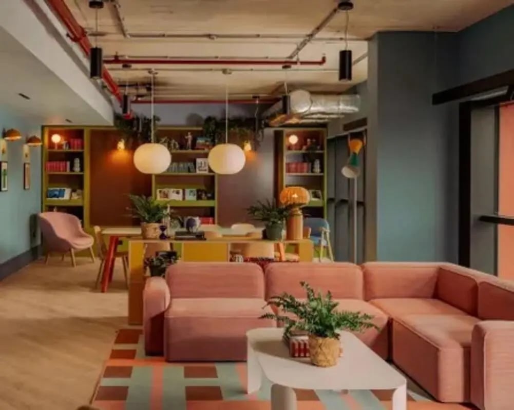 Pink couches shelves table chairs living room at Scape Hammersmith in London Student Accommodation