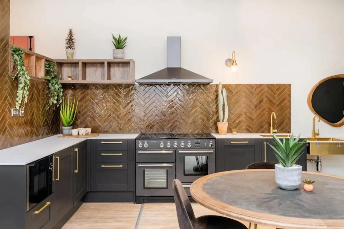 Dark cabinets oven sink plants round table kitchen at Hillfort House in Brighton Student Accommodation