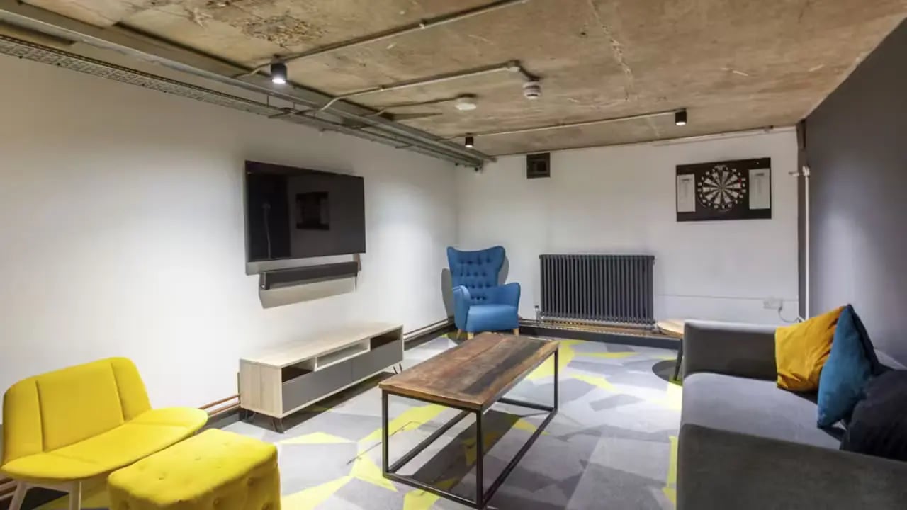 TV blue armchair sofa dartboard living room at Berkshire House Reading in Reading Student Accommodation