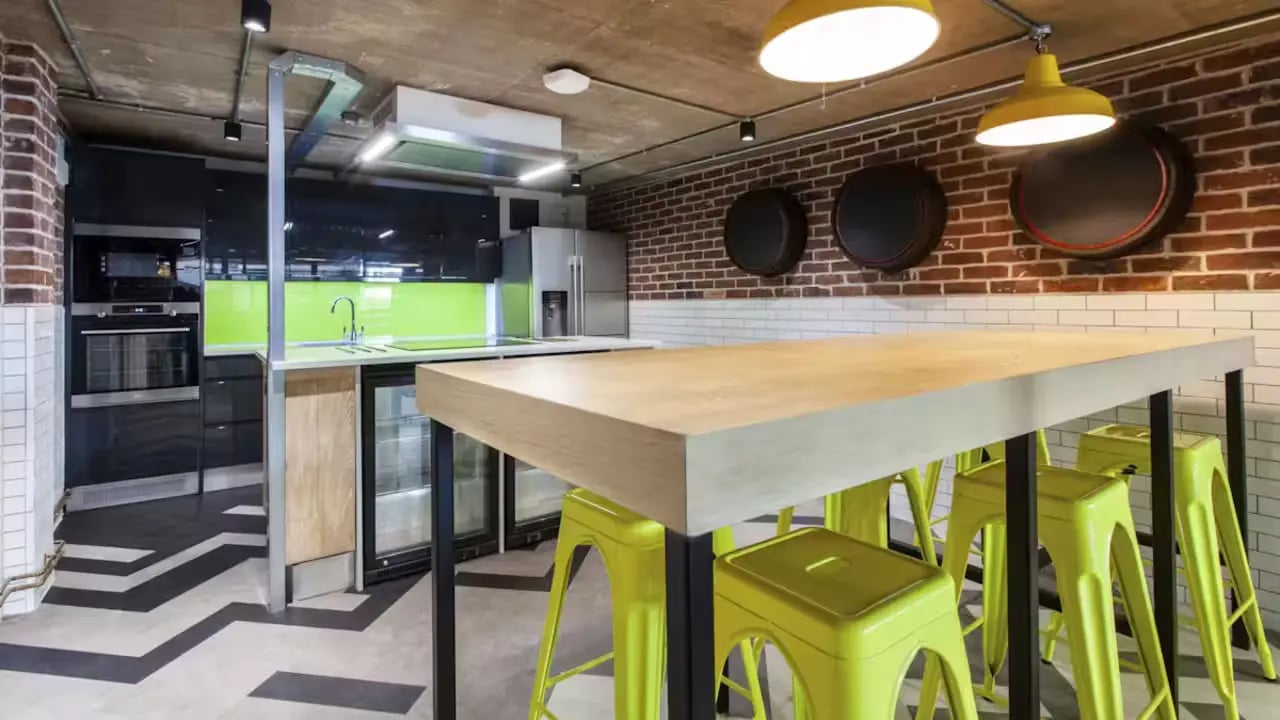 Table with yellow stools kitchen area. at Berkshire House Reading in Reading Student Accommodation