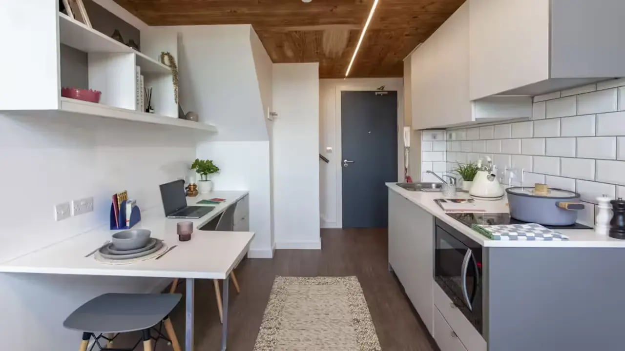Desk laptop shelves kitchen with pots and kettle kitchen at Gillows in Lancaster Student Accommodation