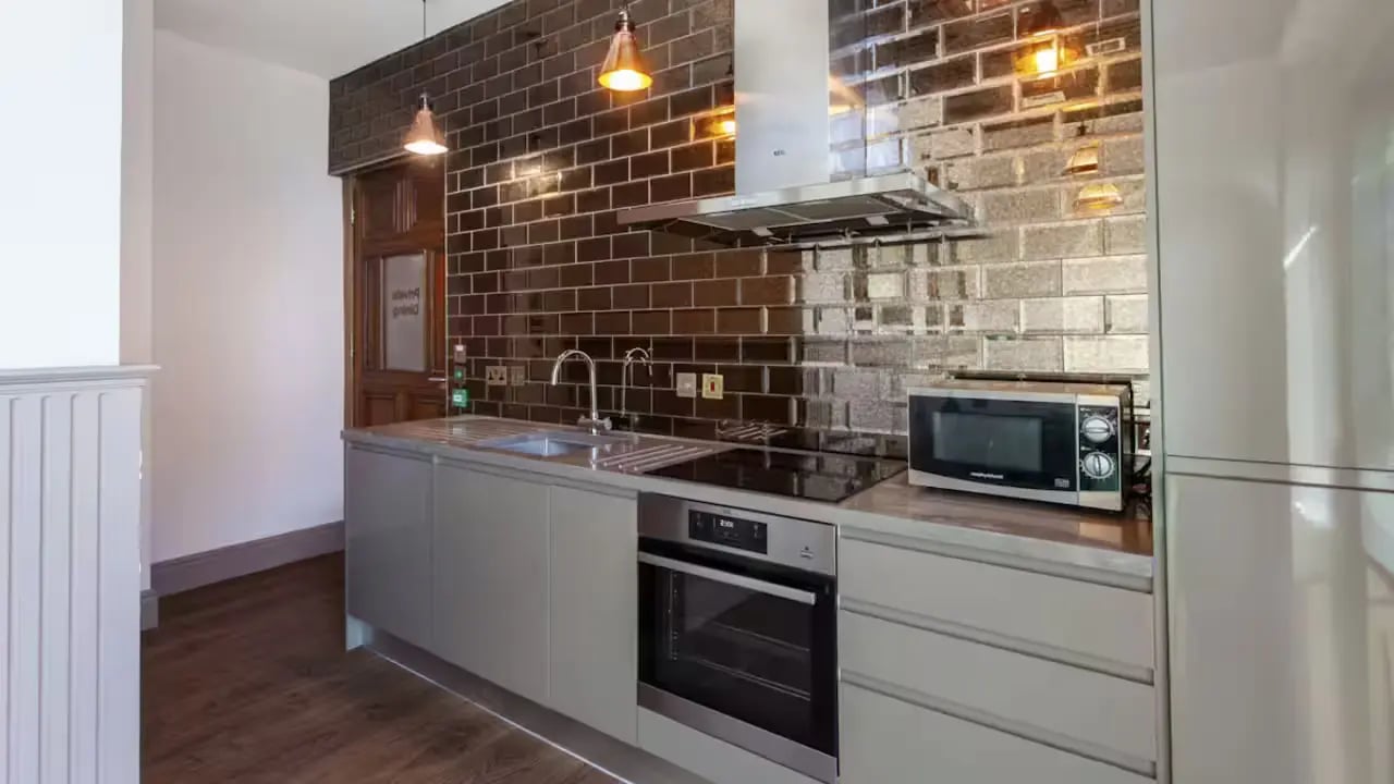 Modern grey cabinets oven microwave tiled backsplash kitchen at Gillows in Lancaster Student Accommodation