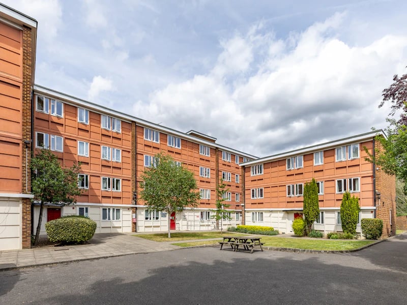 Orange student accommodation building with picnic tables exterior at Brooke Hall in London Student Accommodation