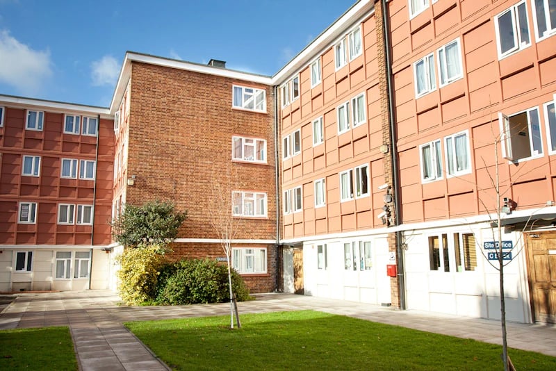 Apartment building with windows and green courtyard exterior at Brooke Hall in London Student Accommodation