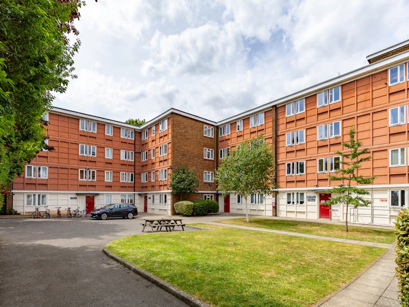 Apartment building with red doors and car exterior at Brooke Hall in London Student Accommodation