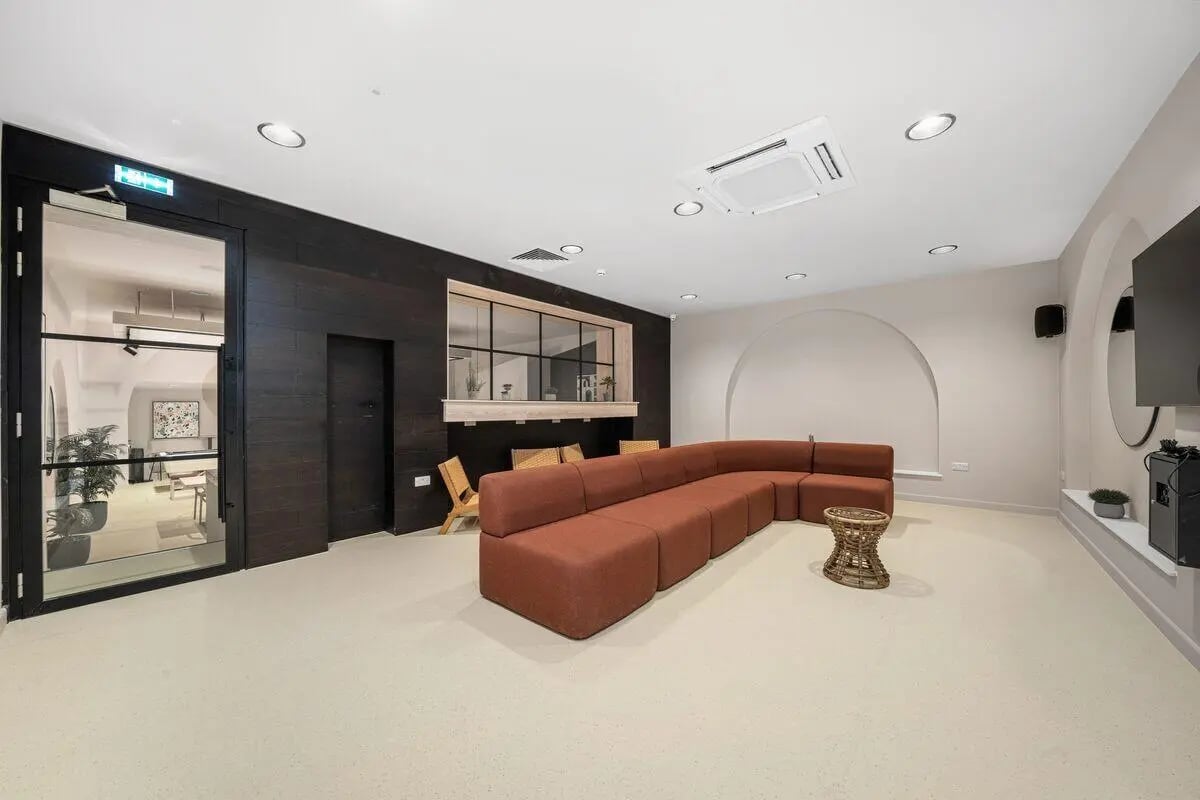 Brown sectional sofa with woven coffee table living room at Cathedral Park in Bristol Student Accommodation