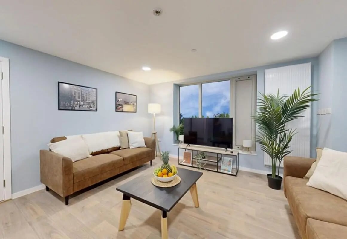 Brown couches coffee table with fruit and TV living room at Brigg Point in Bristol Student Accommodation