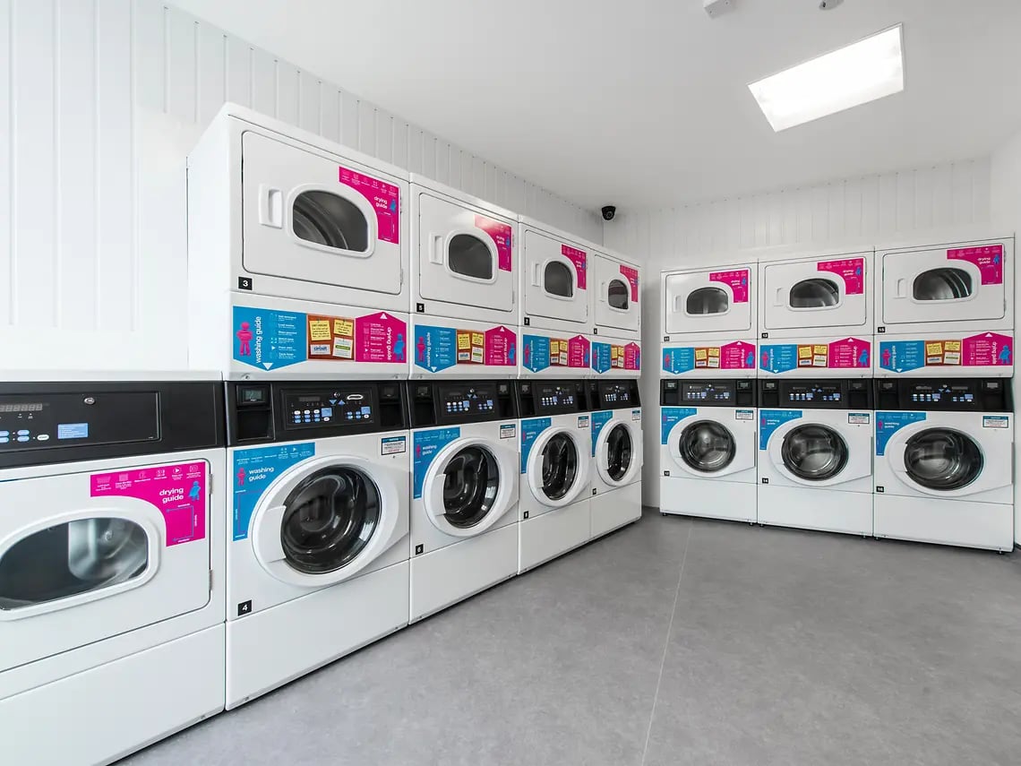 Stacked washers and dryers in a clean laundry room at Yugo Bentley House in Birmingham Student Accommodation