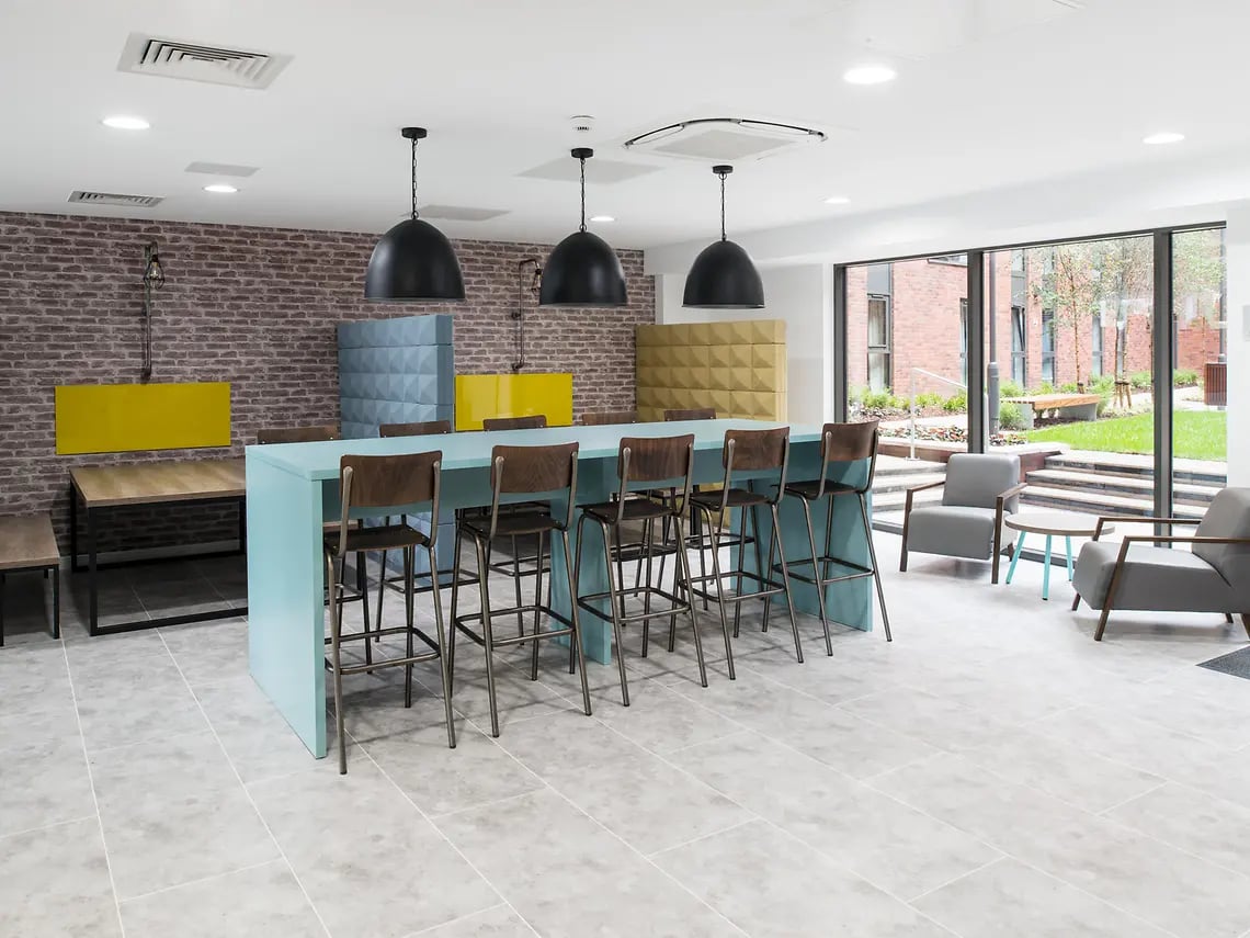 Bar stools at light blue table lounge area at Yugo Bentley House in Birmingham Student Accommodation