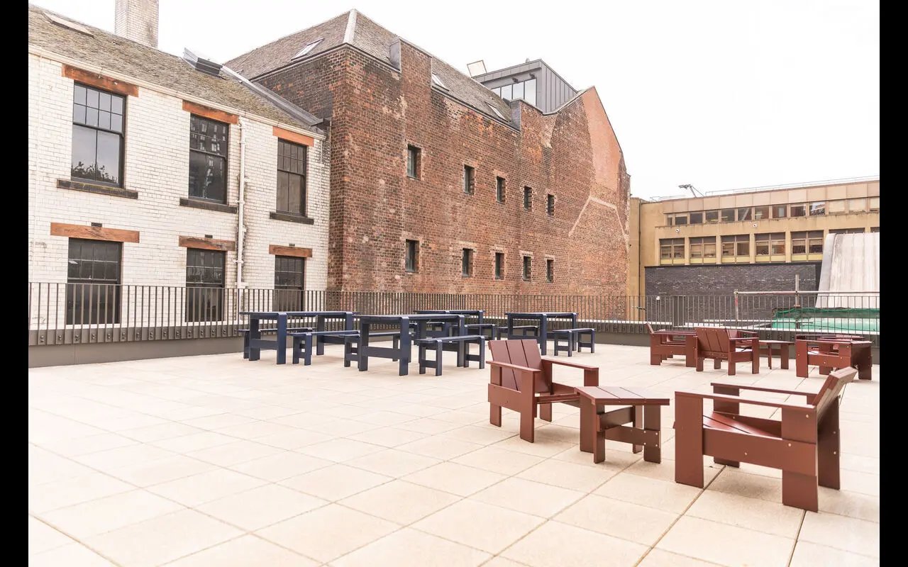Red and blue seating on tiled patio exterior at Martha Street Apartments in Glasgow Student Accommodation