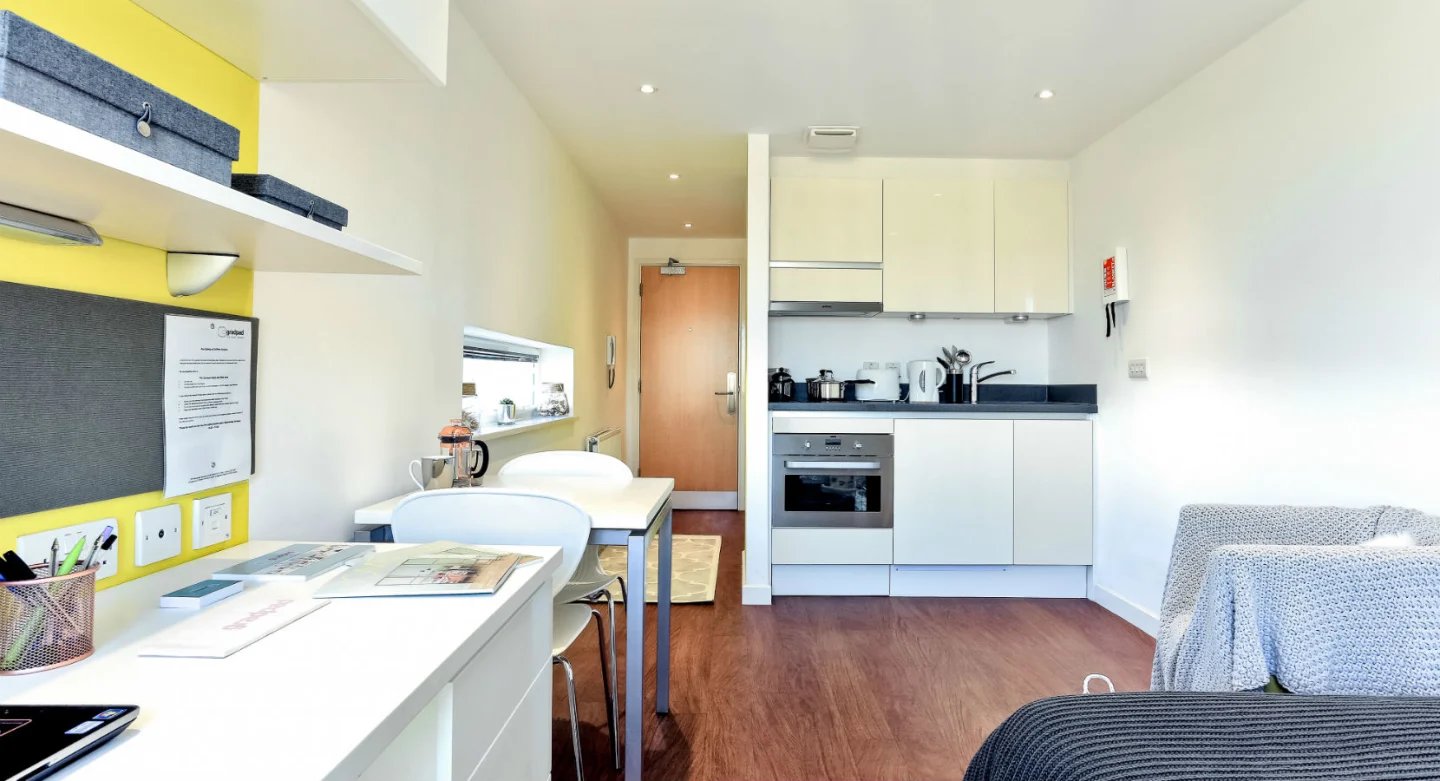 Desk chair kitchen with oven and sofa living room at Griffon Studios in London Student Accommodation
