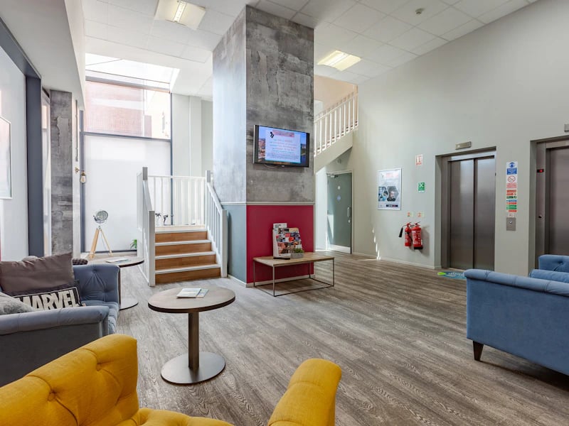 Sofa chairs television stairs elevators lounge at Academic House in London Student Accommodation