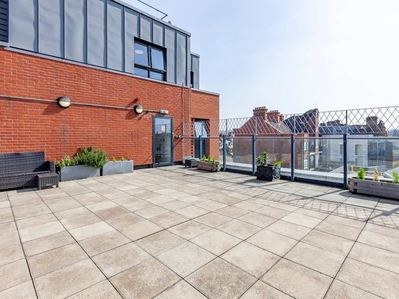 Rattan sofa planters and tiled patio exterior at Academic House in London Student Accommodation