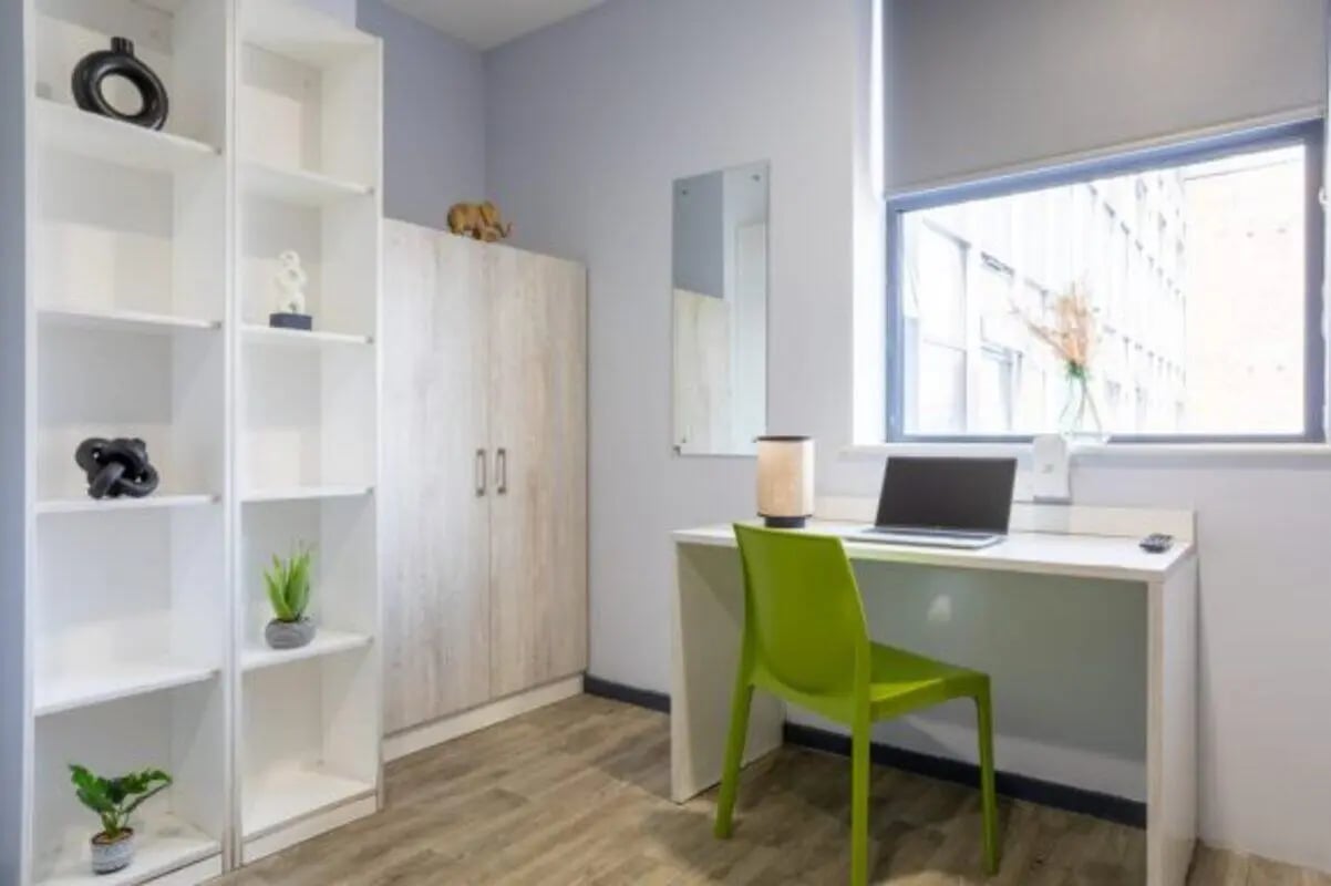 Bookshelf wardrobe desk chair laptop study area at dwell Archer House in Nottingham Student Accommodation