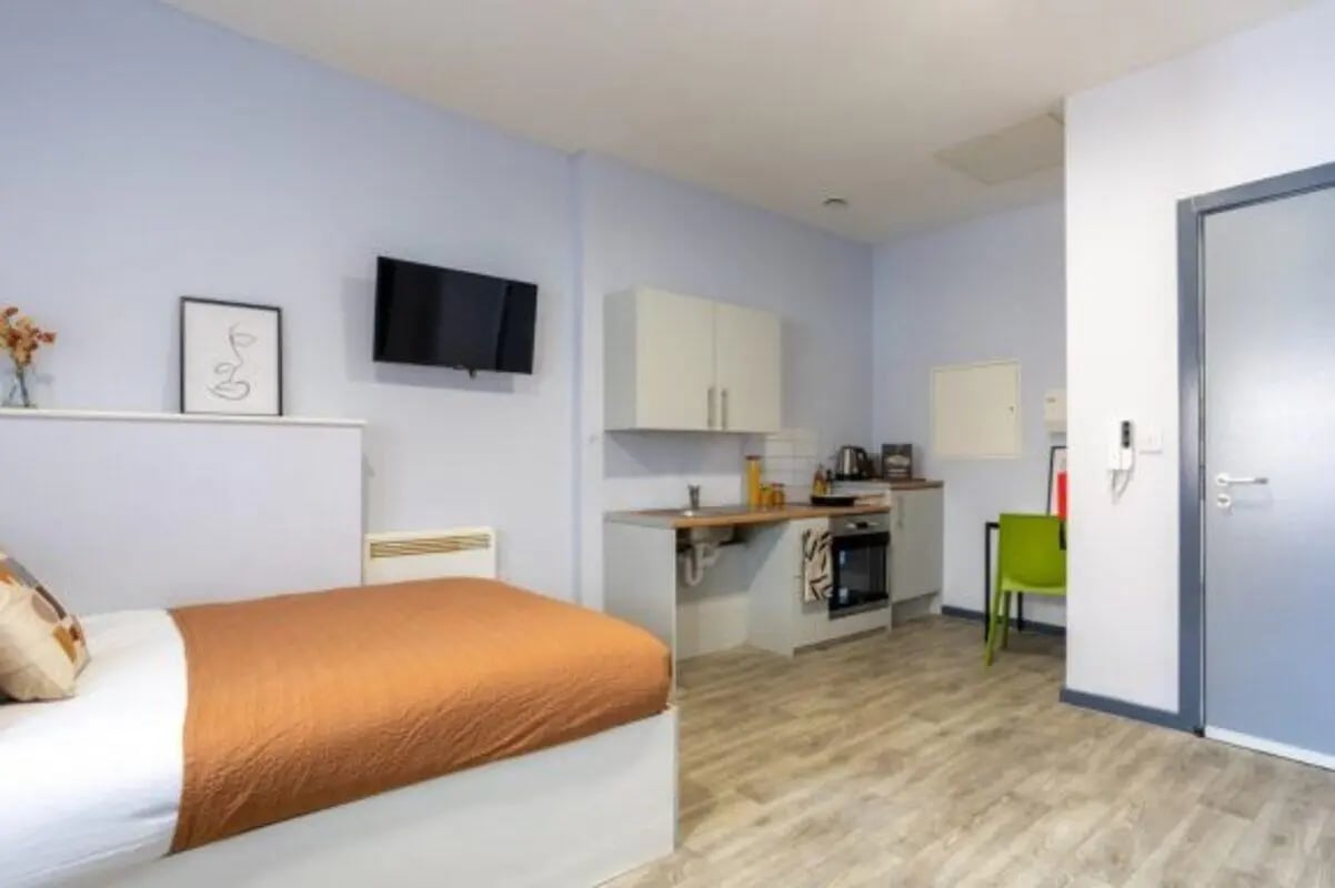Bed kitchen area with oven cabinets chair at dwell Archer House in Nottingham Student Accommodation