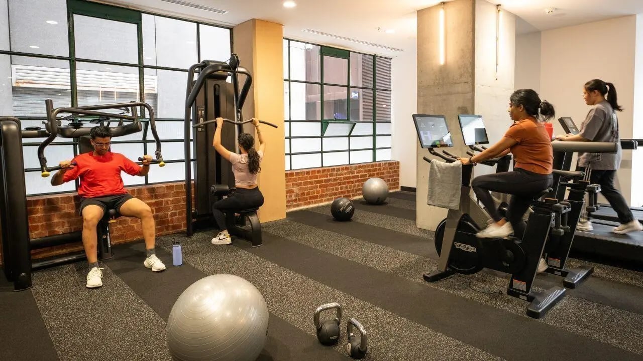 People exercising gym equipment and weights gym at UniLodge Melbourne Flagstaff in Melbourne Student Accommodation