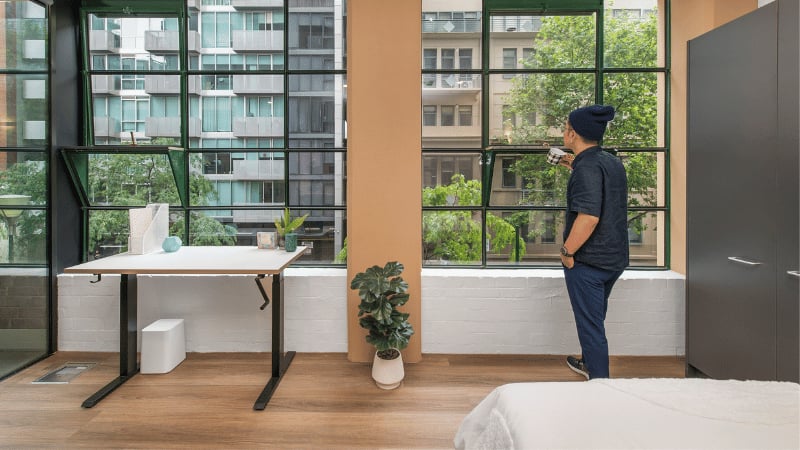Desk plants and man in window bedroom study area at UniLodge Melbourne Flagstaff in Melbourne Student Accommodation