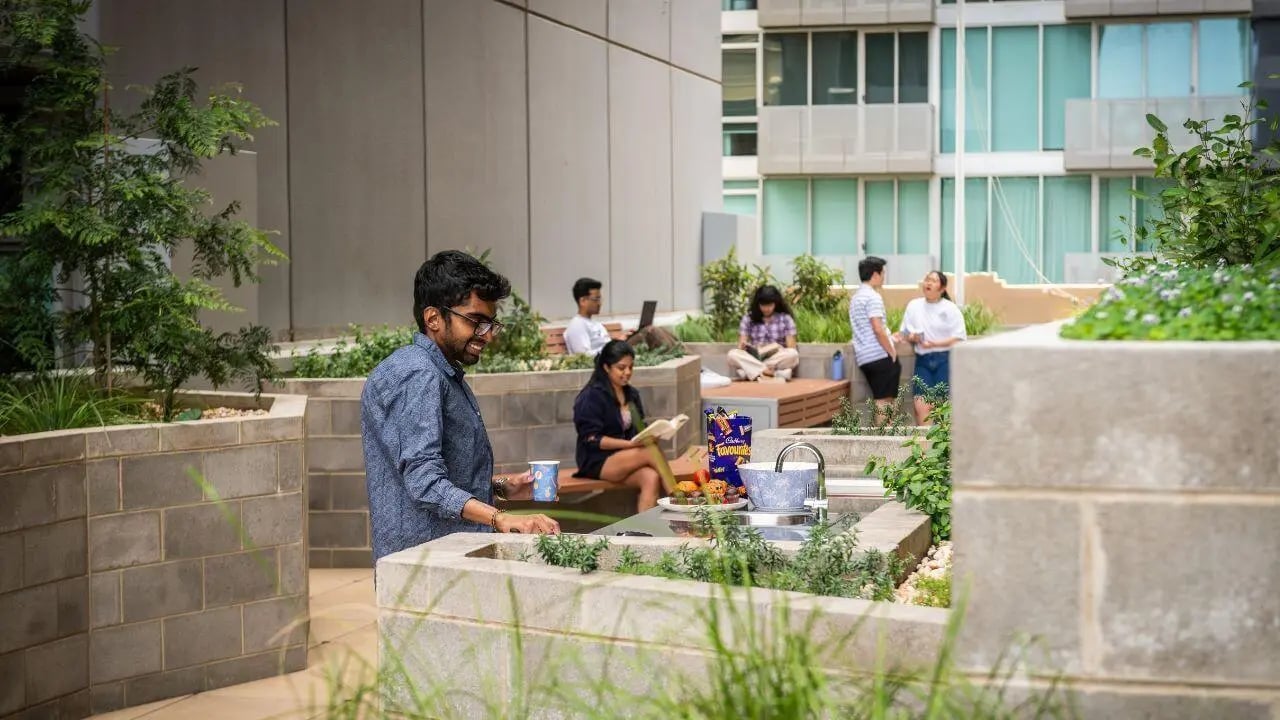 Students socialising at an outdoor communal kitchen area at UniLodge Melbourne Flagstaff in Melbourne Student Accommodation